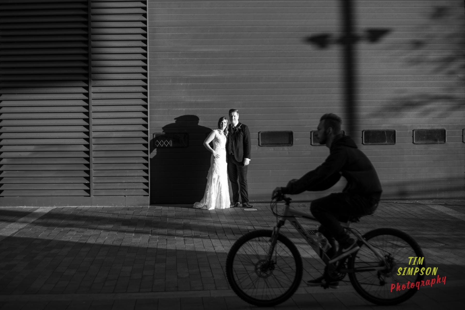 bride and groom with cyclist 