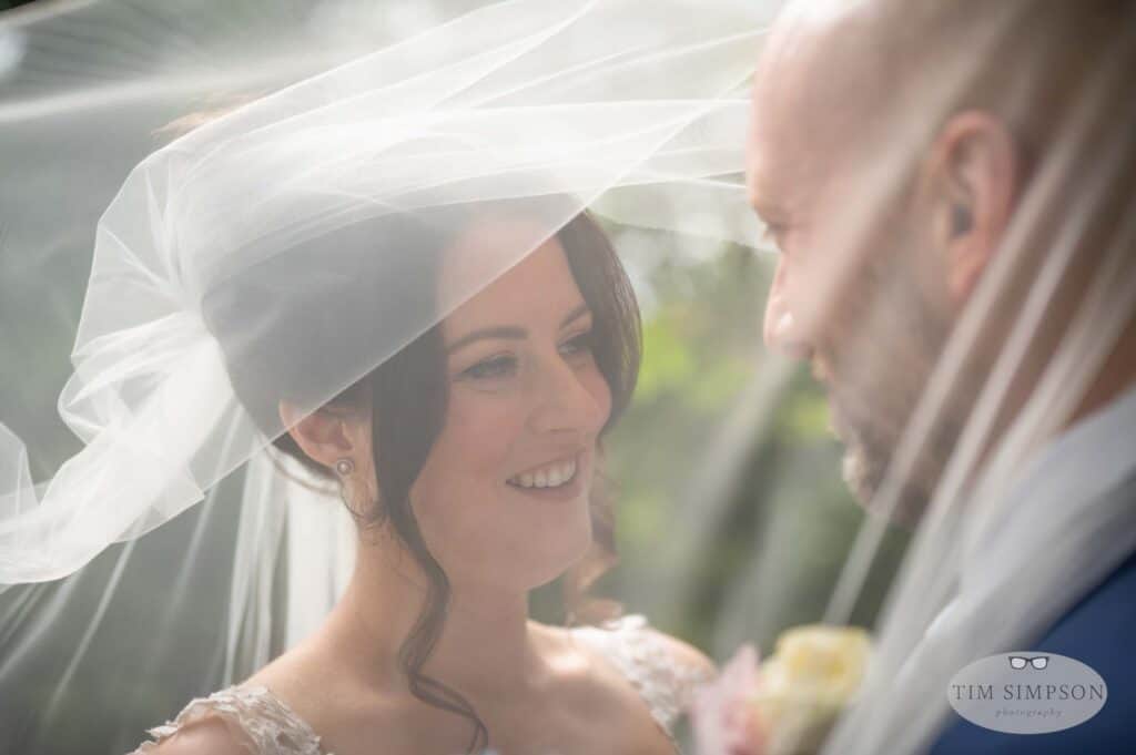 bride and groom under a veil